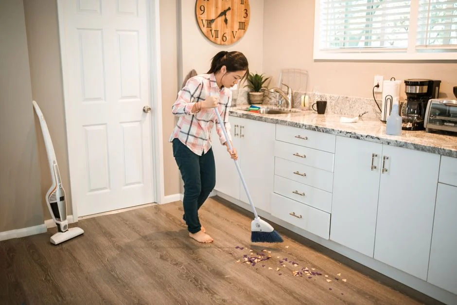 gallery-02 A professional cleaner in protective gear vacuuming the floor in a modern living room.